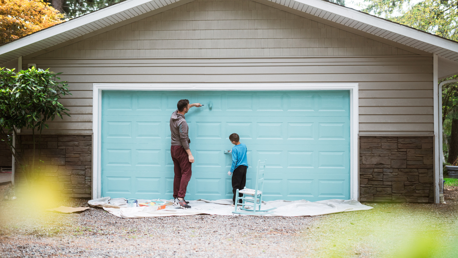 A dad and his child bond as they enjoy togetherness working on getting their home exterior painted.  A fun project for the family and opportunity for the child to grow in responsibility.